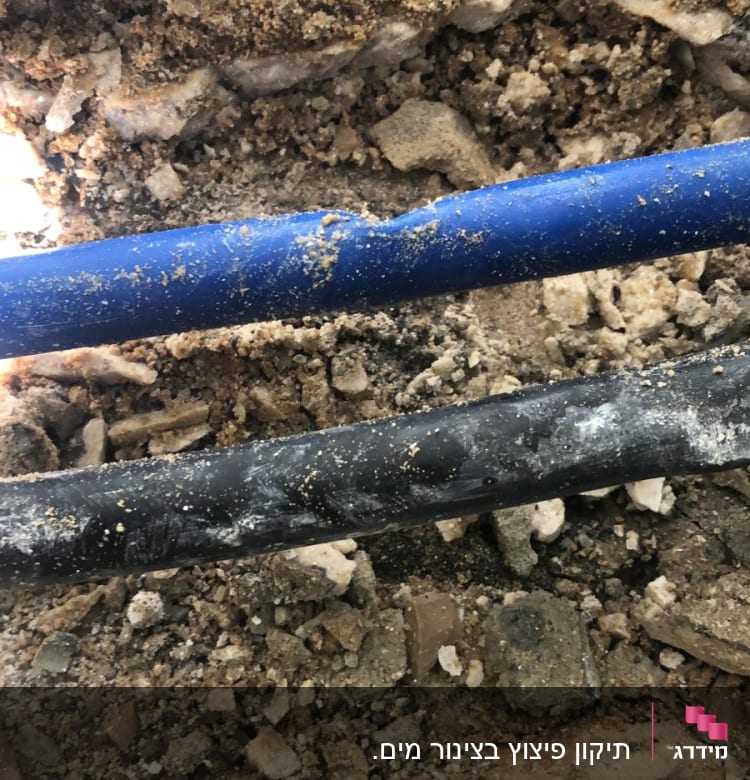 צינורות כחול ושחור בתוך אדמה וחול